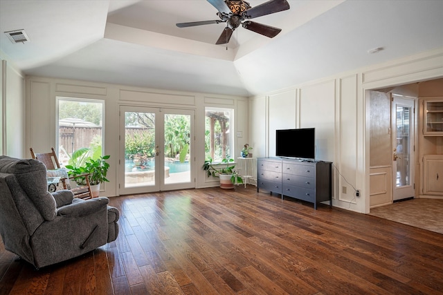 living room featuring dark wood-type flooring, ceiling fan, and vaulted ceiling