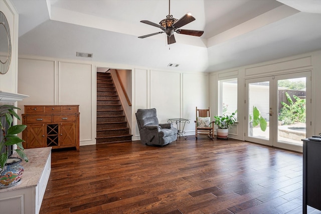 living area featuring dark hardwood / wood-style flooring, a raised ceiling, french doors, and ceiling fan