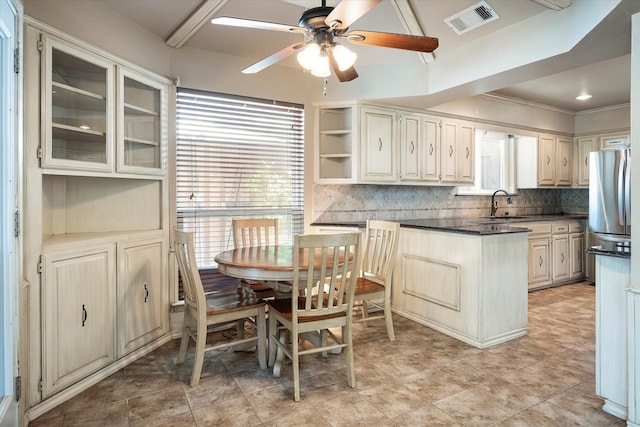 kitchen with tasteful backsplash, sink, stainless steel refrigerator, and ceiling fan