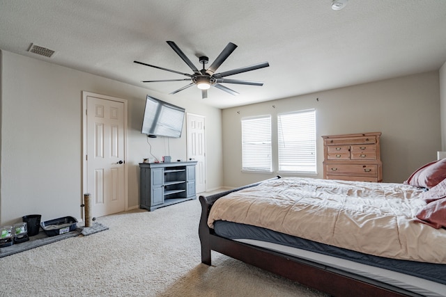 bedroom featuring carpet, ceiling fan, and a textured ceiling