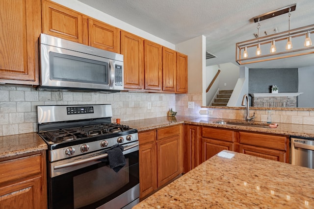 kitchen with stainless steel appliances, backsplash, sink, and a textured ceiling