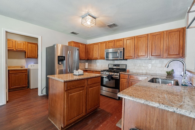 kitchen with sink, appliances with stainless steel finishes, dark wood-type flooring, and tasteful backsplash