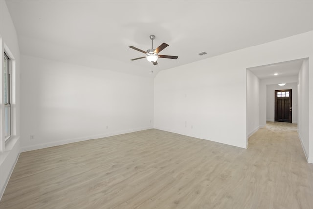 empty room with ceiling fan, vaulted ceiling, and light wood-type flooring