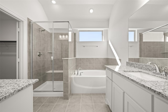 bathroom featuring vanity, lofted ceiling, independent shower and bath, and tile patterned floors