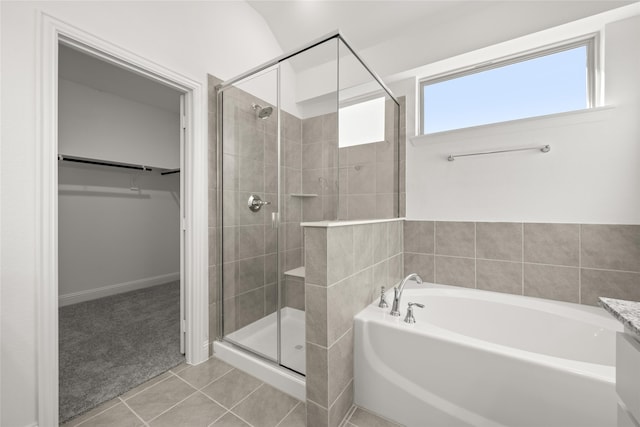 bathroom featuring plus walk in shower and tile patterned flooring