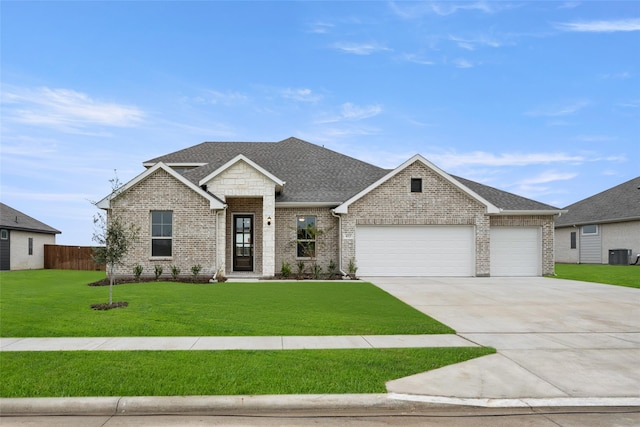 view of front of property with central AC unit, a garage, and a front lawn