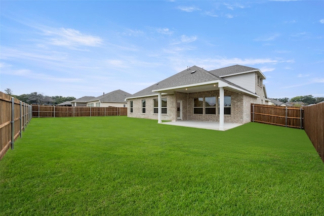 rear view of property featuring a lawn and a patio