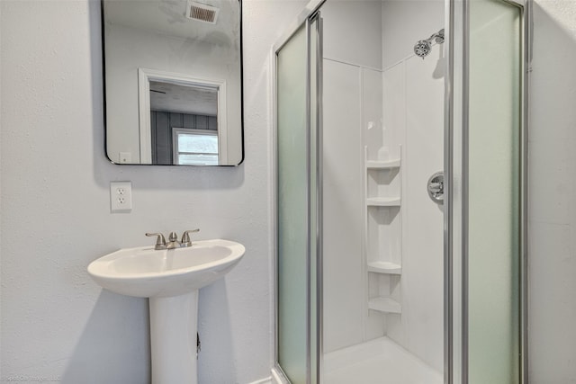 bathroom featuring a shower with door