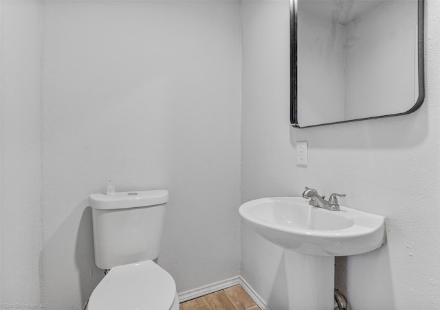 bathroom featuring hardwood / wood-style floors and toilet