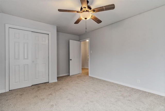 unfurnished bedroom featuring light carpet, ceiling fan, and a closet