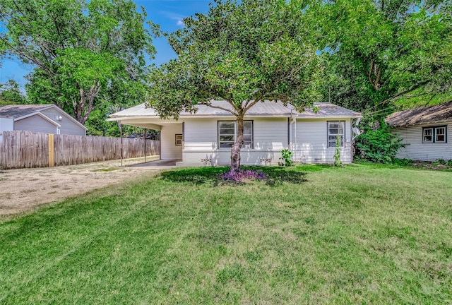 rear view of property featuring a carport and a yard