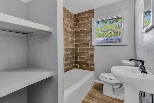 full bathroom with sink, tiled shower / bath combo, wood-type flooring, and toilet