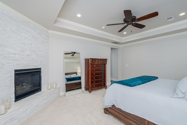 bedroom with a fireplace, carpet, ceiling fan, a raised ceiling, and ornamental molding