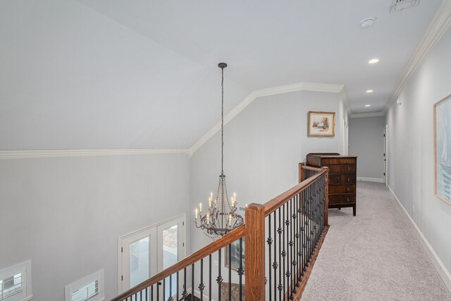 hall with crown molding, a chandelier, vaulted ceiling, and light colored carpet