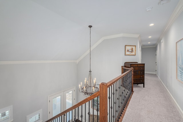 corridor featuring carpet floors, an inviting chandelier, baseboards, and crown molding