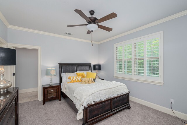 carpeted bedroom with ornamental molding and ceiling fan