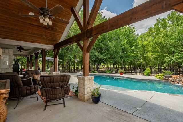 view of swimming pool featuring ceiling fan and a patio area