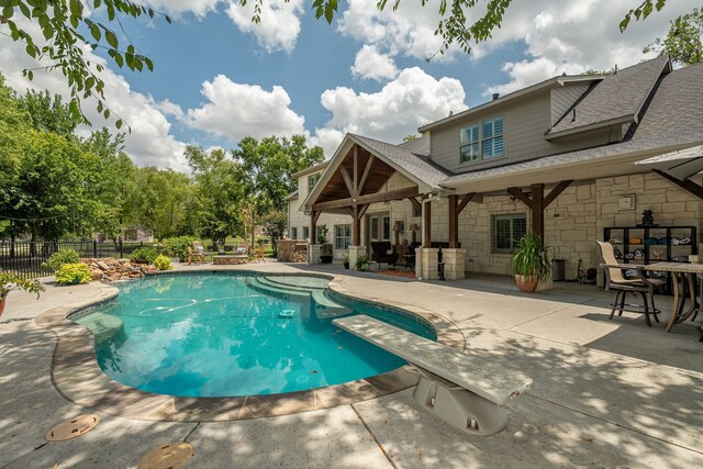 view of pool featuring a patio and a diving board