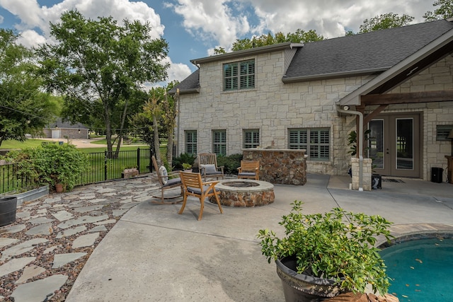 view of patio with a fenced in pool and a fire pit