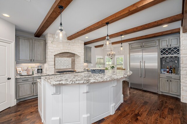 kitchen featuring stainless steel appliances, gray cabinets, decorative light fixtures, a center island, and dark hardwood / wood-style flooring