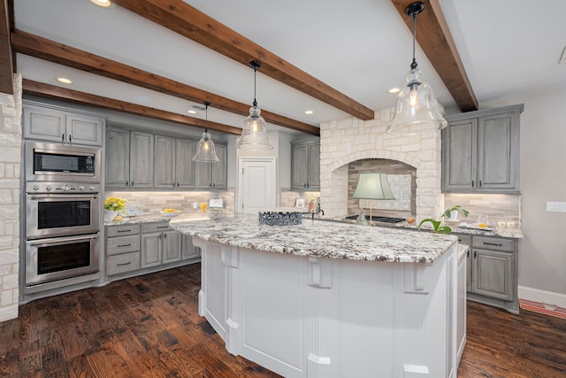 kitchen featuring stainless steel appliances, light stone counters, gray cabinets, and dark wood finished floors