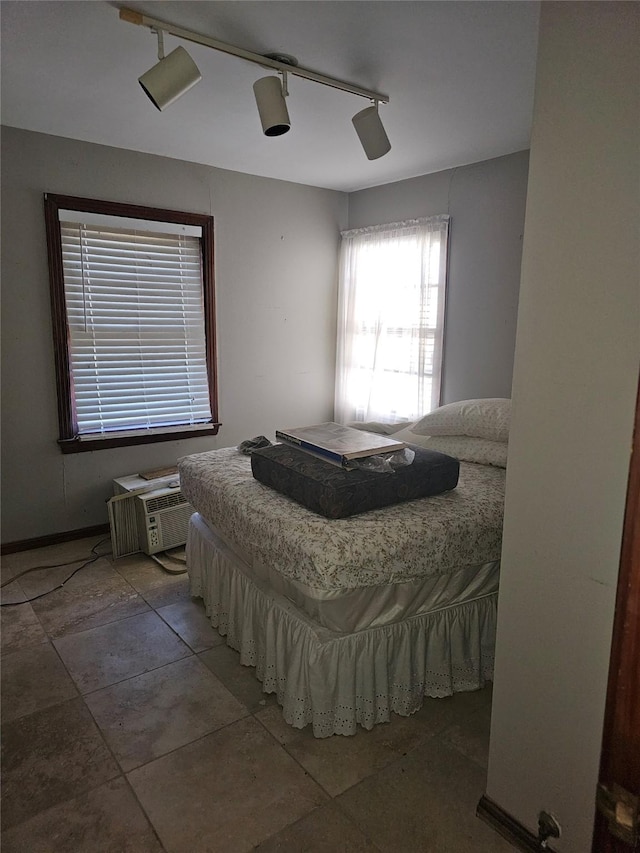 tiled bedroom featuring a wall unit AC, ceiling fan, and rail lighting