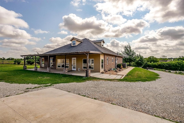 rear view of property featuring covered porch and a lawn