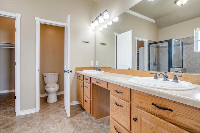 bathroom featuring toilet, ornamental molding, vanity, a shower with door, and tile patterned flooring