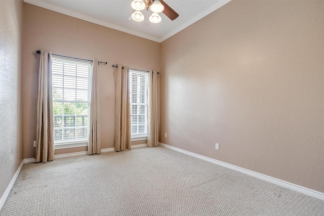 carpeted spare room featuring crown molding, plenty of natural light, and ceiling fan