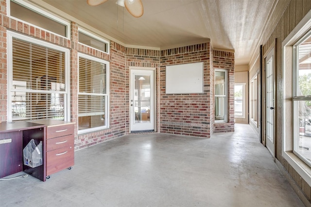 unfurnished sunroom with ceiling fan