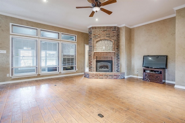 unfurnished living room with crown molding, a fireplace, light hardwood / wood-style floors, and ceiling fan