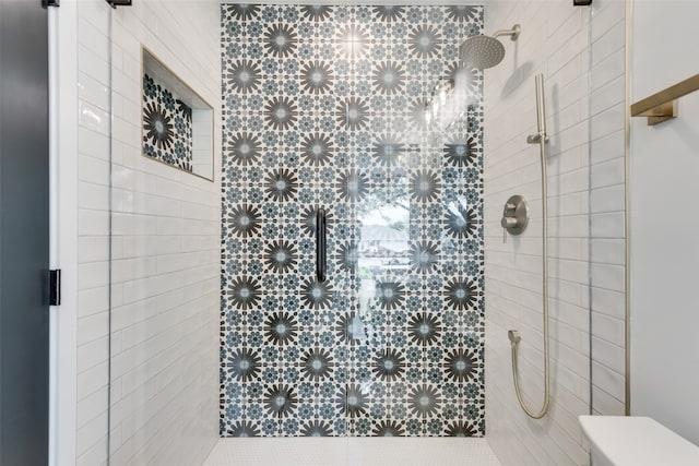 bathroom with toilet and tiled shower