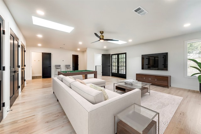 living room with a skylight, ceiling fan, pool table, and light hardwood / wood-style floors