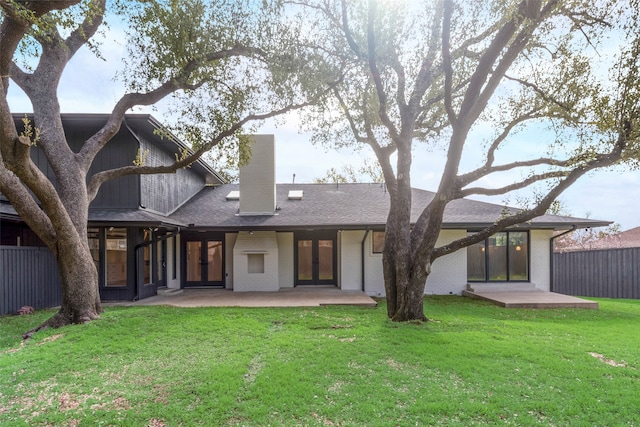 back of property with a yard and a patio