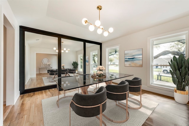 dining area with a chandelier and light hardwood / wood-style flooring