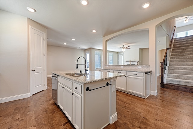 kitchen with dishwasher, a kitchen island with sink, ceiling fan, hardwood / wood-style floors, and sink