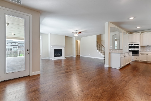 unfurnished living room with hardwood / wood-style flooring and ceiling fan