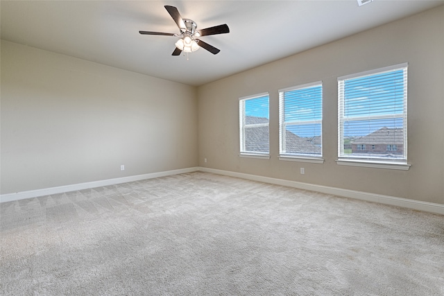 carpeted spare room featuring ceiling fan