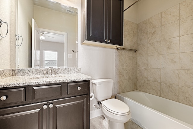 full bathroom featuring vanity, tile patterned floors, ceiling fan, tiled shower / bath combo, and toilet