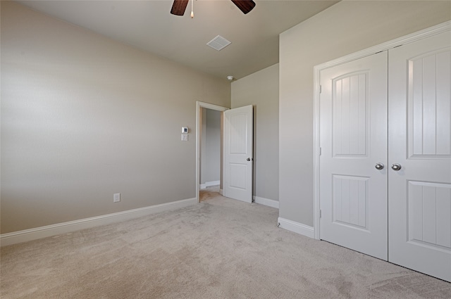 unfurnished bedroom featuring light carpet, a closet, and ceiling fan