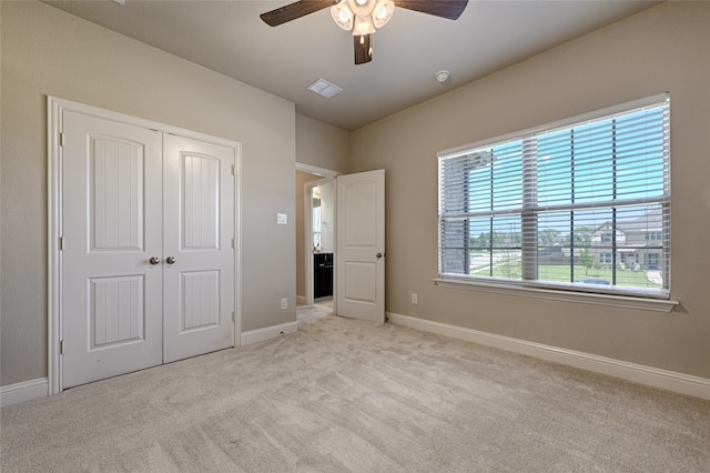 unfurnished bedroom featuring a closet, ceiling fan, and light colored carpet