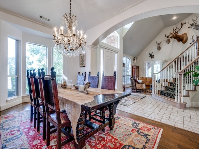 dining space featuring lofted ceiling, crown molding, and hardwood / wood-style flooring