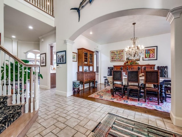 dining space with a notable chandelier, crown molding, and decorative columns