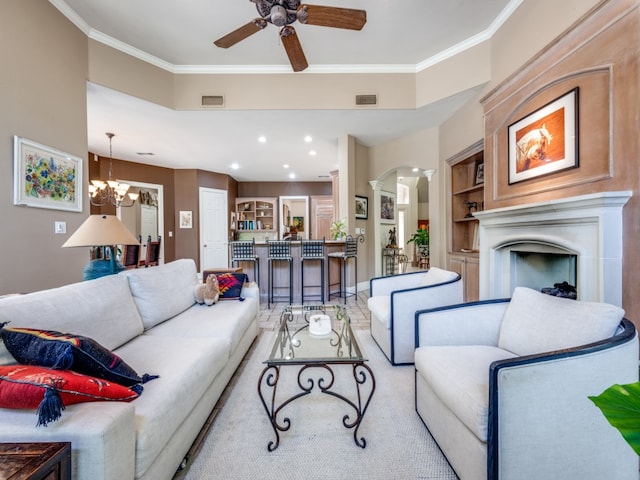 living room featuring ceiling fan with notable chandelier, built in features, and ornamental molding