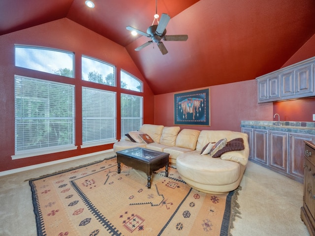 carpeted living room featuring vaulted ceiling, sink, and ceiling fan