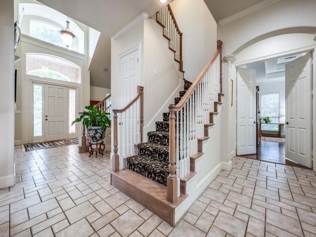 entrance foyer featuring a towering ceiling and ornamental molding