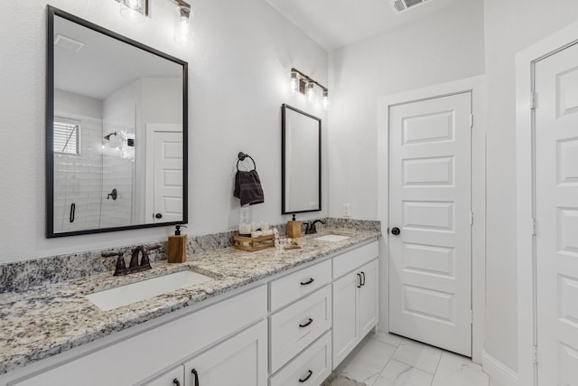 bathroom with a shower, double vanity, and tile patterned flooring