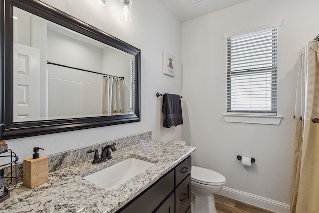 bathroom with vanity, toilet, and hardwood / wood-style floors