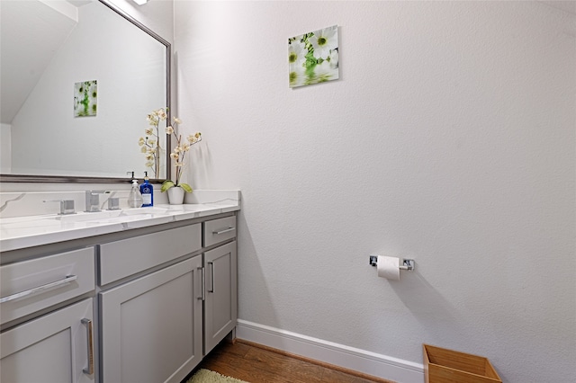 bathroom featuring lofted ceiling, vanity, and hardwood / wood-style floors