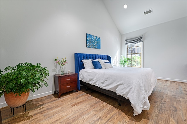 bedroom featuring hardwood / wood-style floors and high vaulted ceiling